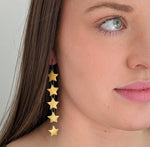 five gold enameled star earring on model