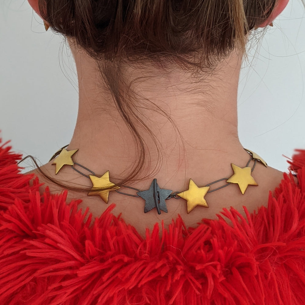 
                
                    Load image into Gallery viewer, gold enameled multi star necklace on model clasp close up
                
            