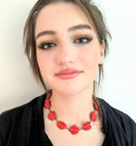abstract red shapes necklace on model in black shirt