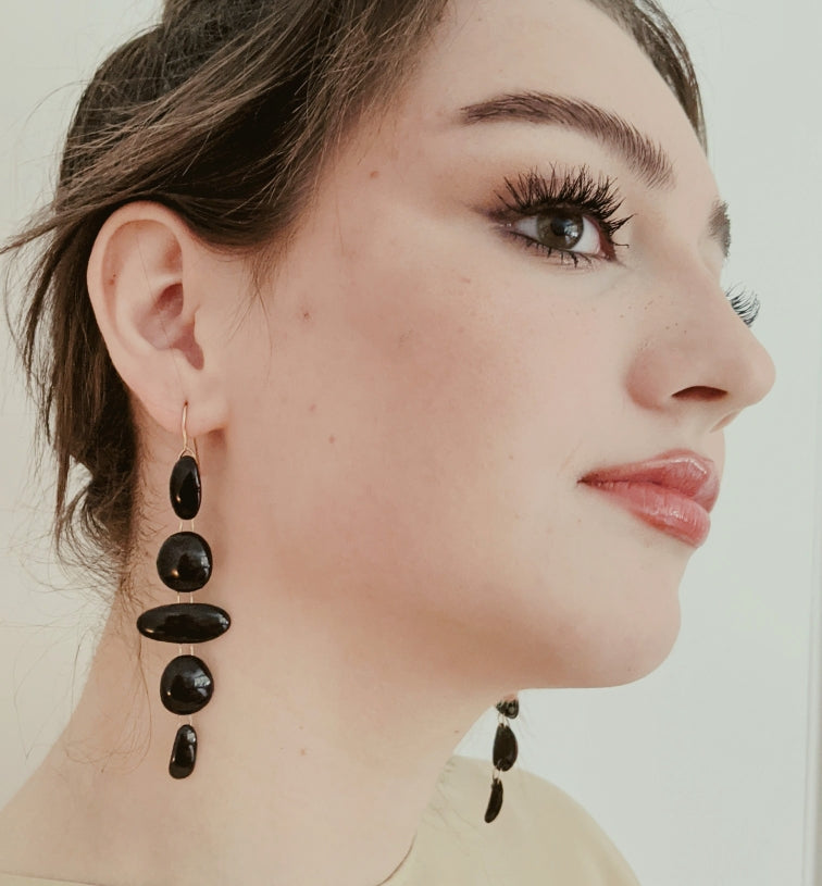 
                
                    Load image into Gallery viewer, 5 link black enamel oval and circles earrings on gold wire on model three quarters view
                
            