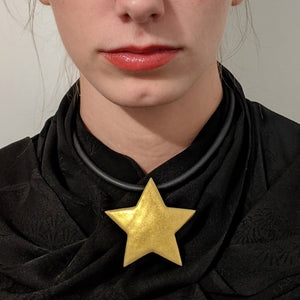 large gold enameled star necklace on model