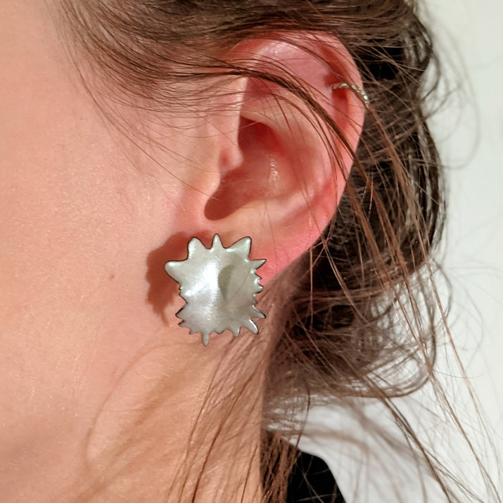 metallic silver burst earring on ear