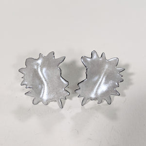 metallic silver burst stud earrings close up 